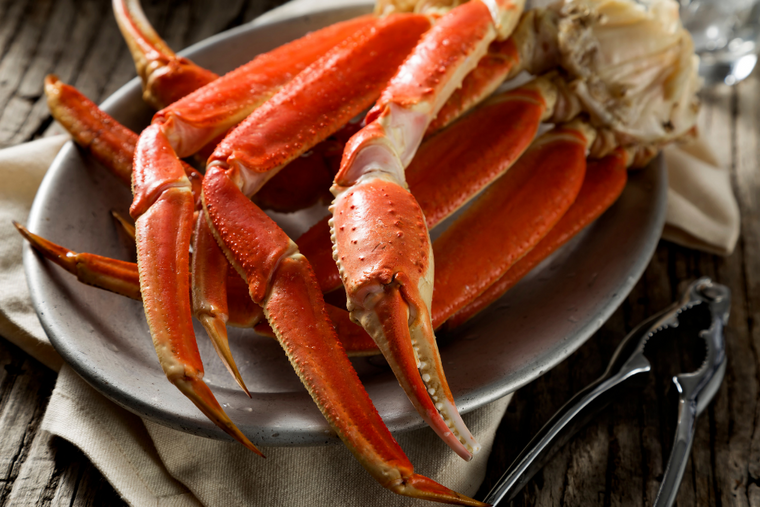Snow crab clusters on plate with crab crackers on the side