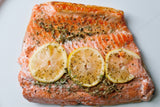 Close up of cooked salmon fillet with herbs and lemon slices on top thumbnail