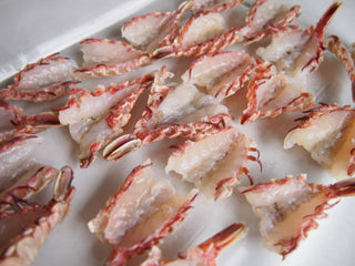 Raw and split cleaned rock shrimp laid open on white plate 