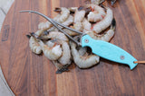 Shrimp deveiner on top of headless white shrimp  thumbnail