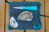 Oyster knife, shucked oyster on top of cut-proof oyster shucking cloth thumbnail