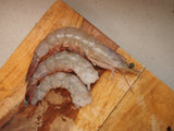 Whole, headless and peeled white shrimp on wood cutting board thumbnail