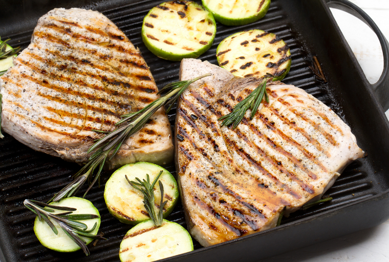 Cooked Swordfish steaks with grill marks with zucchini and rosemary